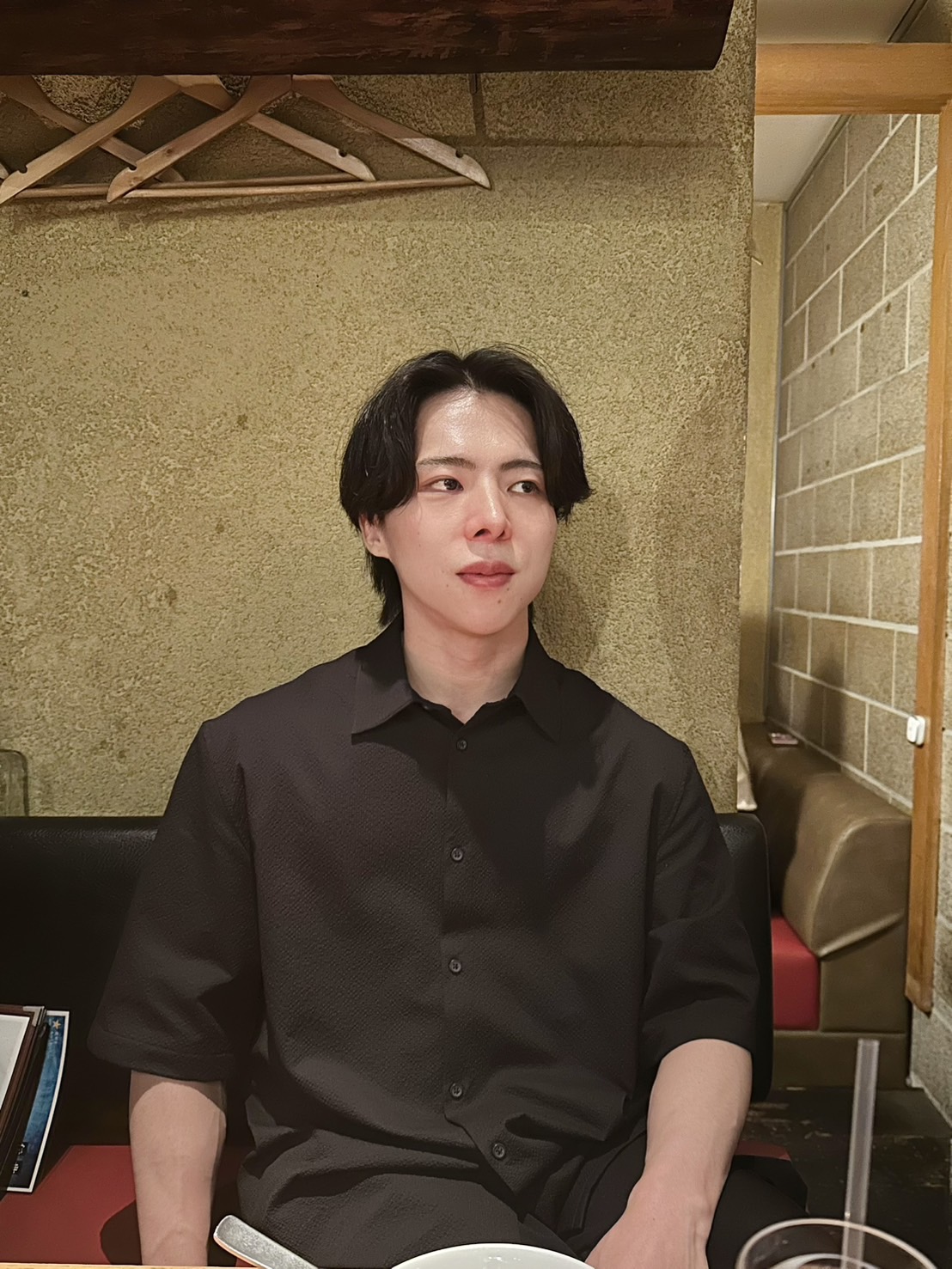 Jeanine White smiling in a red plaid shirt and tortoise shell glasses